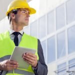 Young male architect with digital tablet looking away outside building - Architecture GOLN [ en.architecture.gurukul.edu.bd ]